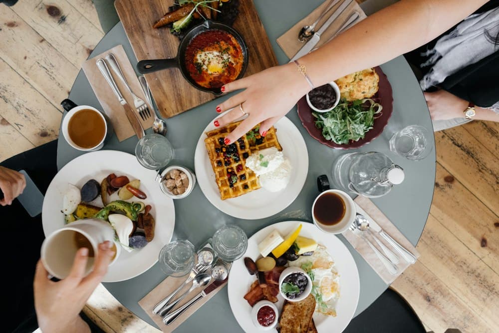 Hands passing plates across a shared table